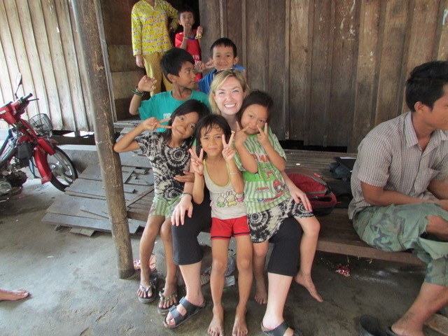 Researcher Kyly Whitfield surrounded by Cambodian children